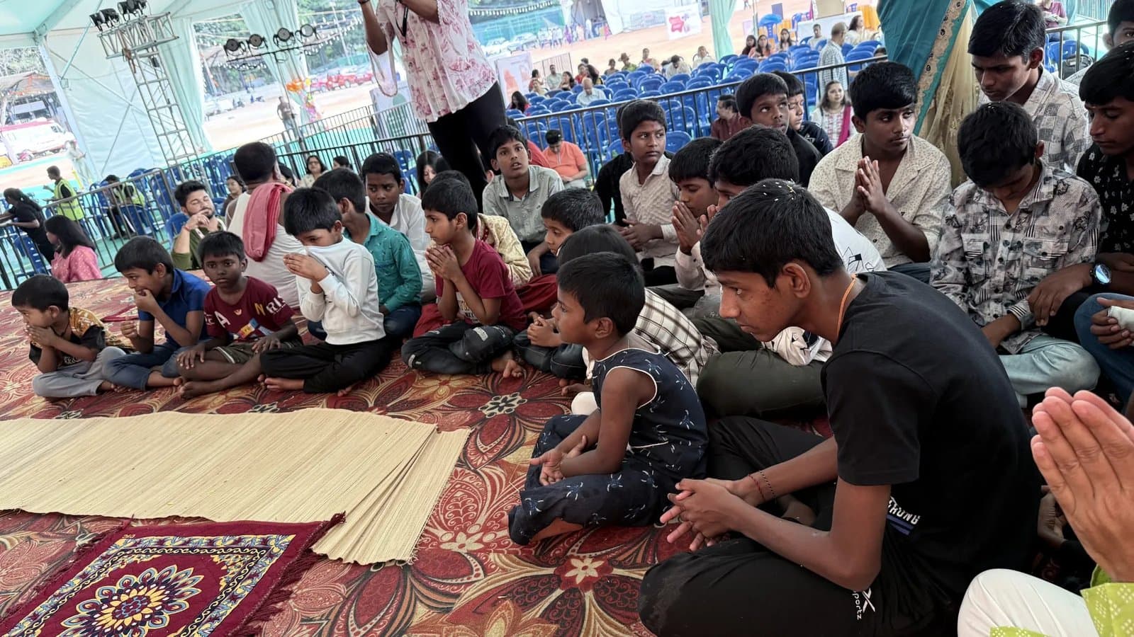 Children who were guests at Durgapatra Abhiyan 2025, seated on the stage with folded hands, waiting for the blessings of Maa Durga