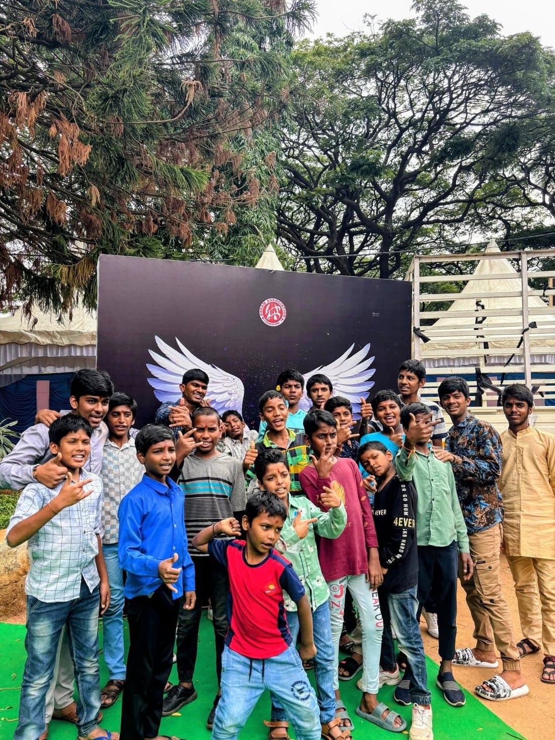Durgapatra Abhiyan 2025 guests smiling and making hand signs for the camera in front of the AAB wings photo backdrop
